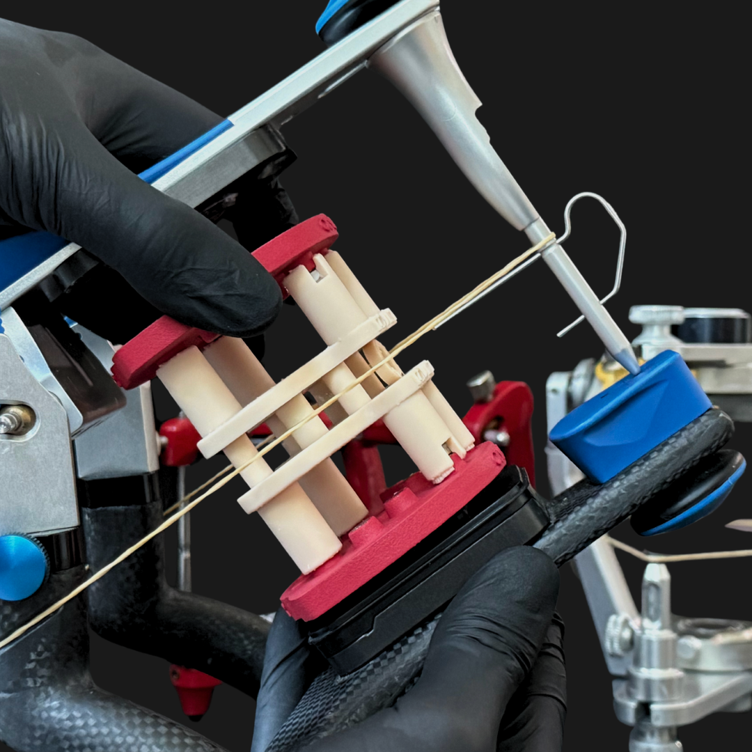 Flex kit being installed: red Flex plates with Gemini Calibrator stacked between them, on a SAM articulator with the Bonwill elastic visible.